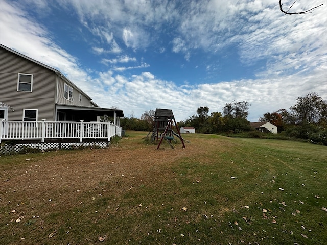 view of yard with a playground and a wooden deck