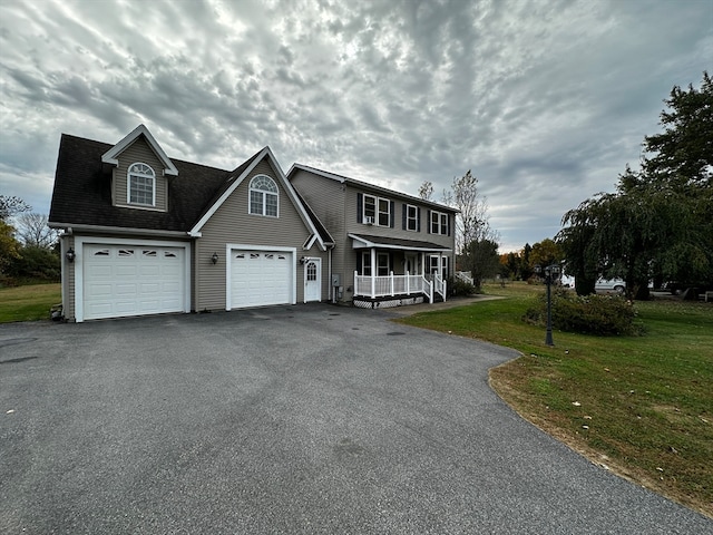 front of property with a garage, a front yard, and a porch