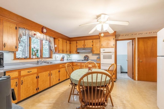 46 Pleasant St, Southbridge, MA 01550 - kitchen with white oven, under cabinet range hood, a sink, and brown cabinets