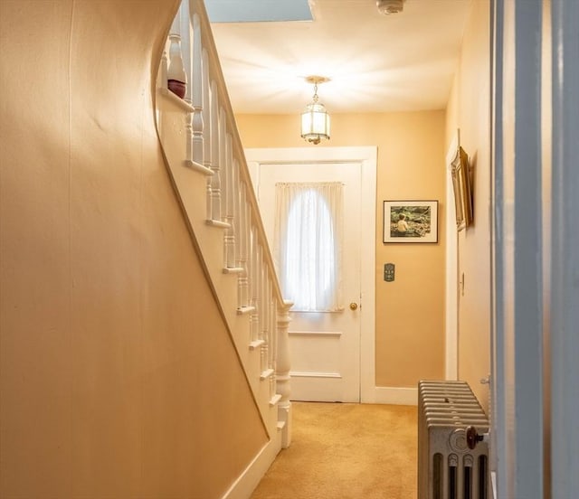 46 Pleasant St, Southbridge, MA 01550 - doorway featuring radiator heating unit, light colored carpet, stairway, and baseboards