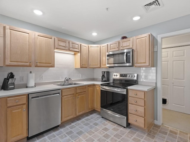 kitchen with tasteful backsplash, sink, light brown cabinets, and appliances with stainless steel finishes