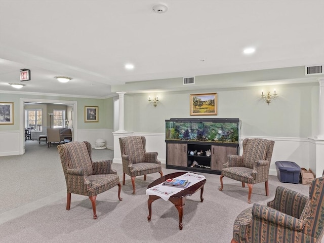 carpeted living room with ornate columns and ornamental molding