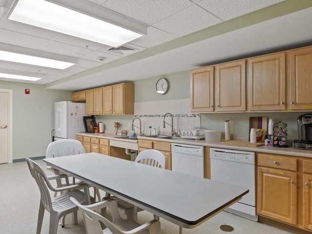 kitchen featuring white appliances, sink, a paneled ceiling, and decorative backsplash