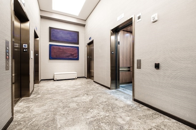 corridor with a towering ceiling and elevator