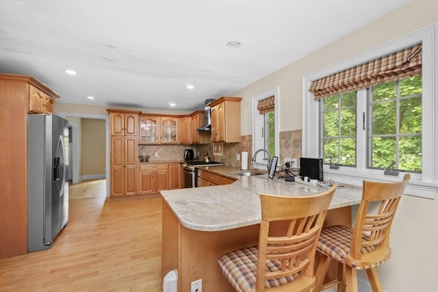 768 Plymouth St, Abington, MA 02351 - kitchen featuring stainless steel appliances, a peninsula, light wood-type flooring, backsplash, and a breakfast bar