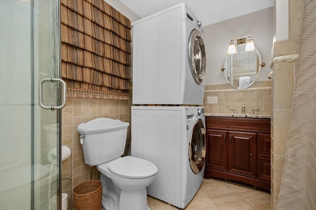 768 Plymouth St, Abington, MA 02351 - full bathroom with stacked washing machine and dryer, tile walls, a stall shower, tile patterned floors, and vanity