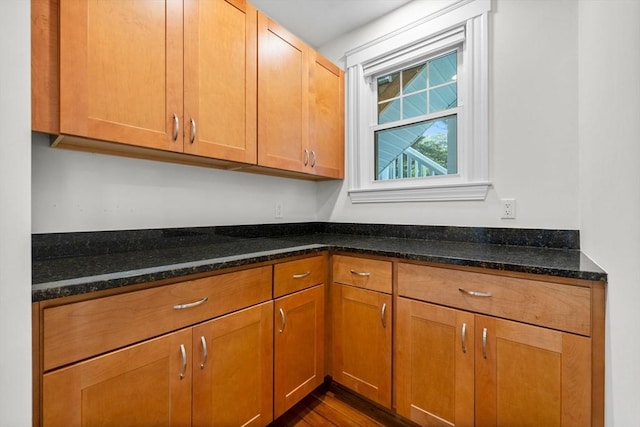 37 Fountain Rd Unit 1, Arlington, MA 02476 - kitchen featuring dark stone countertops, brown cabinets, and dark wood finished floors