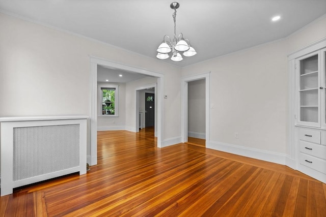 37 Fountain Rd Unit 1, Arlington, MA 02476 - spare room featuring radiator, a chandelier, wood finished floors, crown molding, and baseboards
