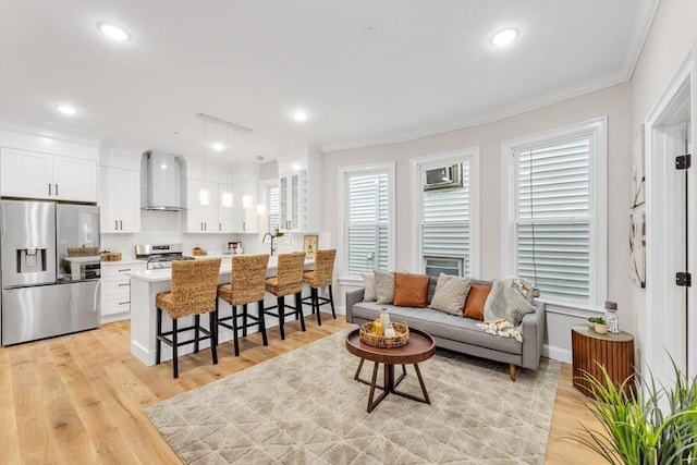 living room featuring light hardwood / wood-style floors and crown molding