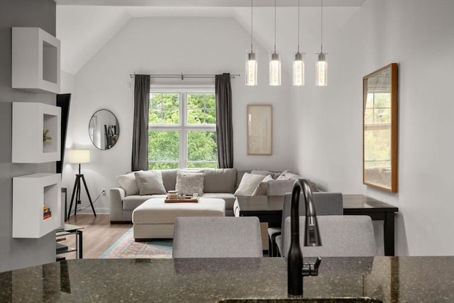 living room featuring wood finished floors, high vaulted ceiling, and baseboards