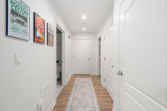 hall with light wood finished floors and recessed lighting