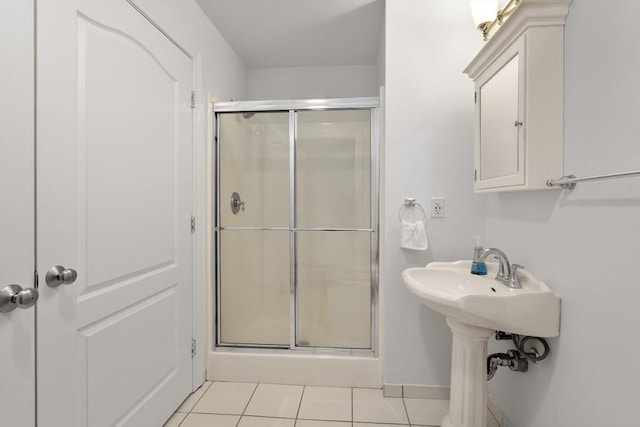bathroom with a stall shower and tile patterned floors