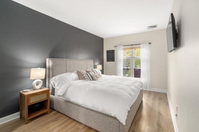bedroom with light wood-style floors and baseboards