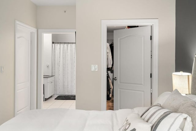 bedroom with light tile patterned floors and ensuite bathroom