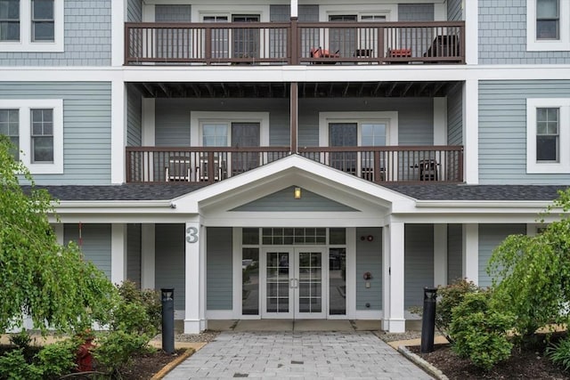 property entrance featuring a balcony and french doors
