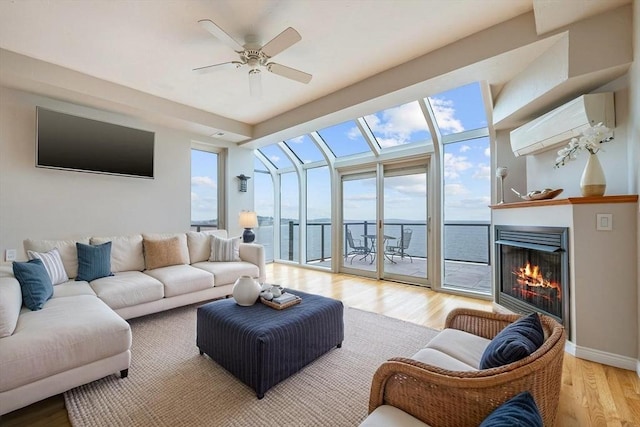 40 Oceanside Dr Unit 40, Hull, MA 02045 - living area featuring a wall mounted air conditioner, light wood finished floors, a lit fireplace, and a ceiling fan