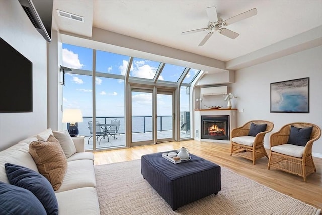 40 Oceanside Dr Unit 40, Hull, MA 02045 - living room featuring wood finished floors, a lit fireplace, ceiling fan, and a wall mounted AC