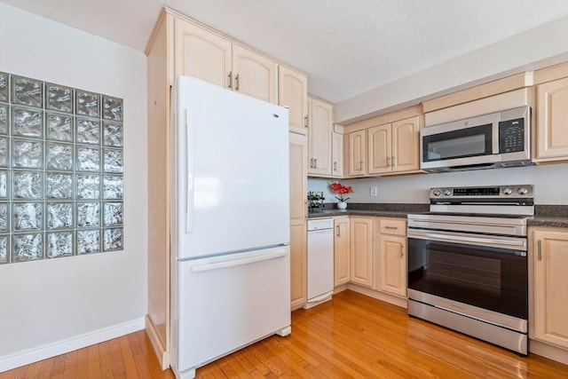40 Oceanside Dr Unit 40, Hull, MA 02045 - kitchen featuring stainless steel appliances, dark countertops, light wood-style flooring, and light brown cabinetry