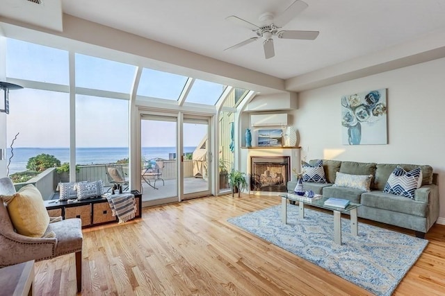 40 Oceanside Dr Unit 40, Hull, MA 02045 - living room featuring a ceiling fan, wood finished floors, a water view, and a fireplace