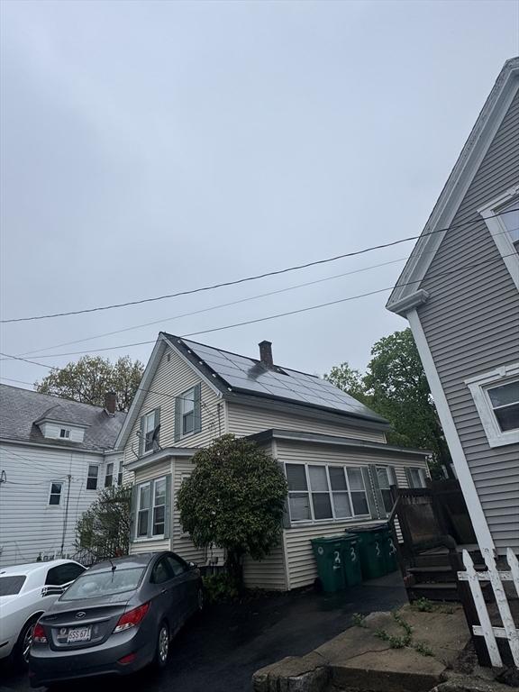 view of home's exterior featuring a chimney and solar panels