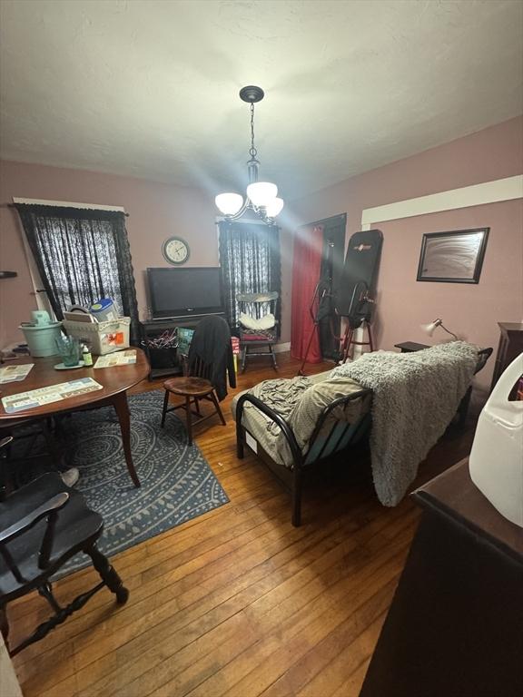 bedroom featuring hardwood / wood-style floors and a chandelier