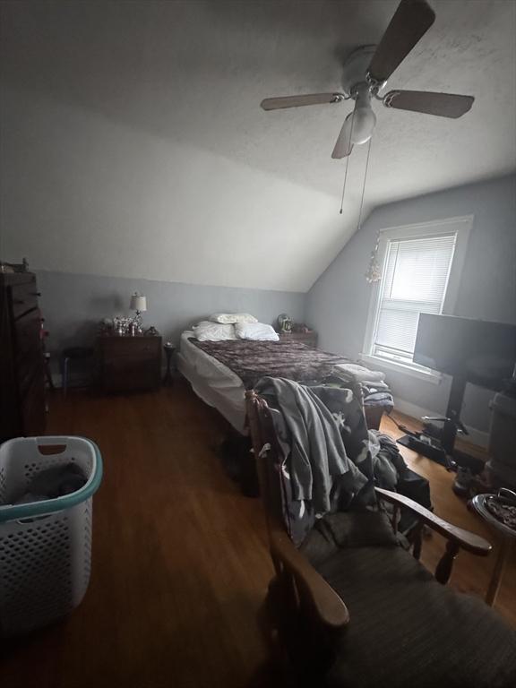 bedroom with wood finished floors, vaulted ceiling, and ceiling fan