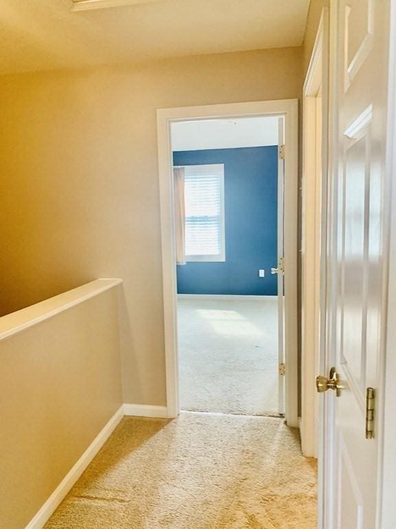 corridor featuring carpet flooring and baseboards