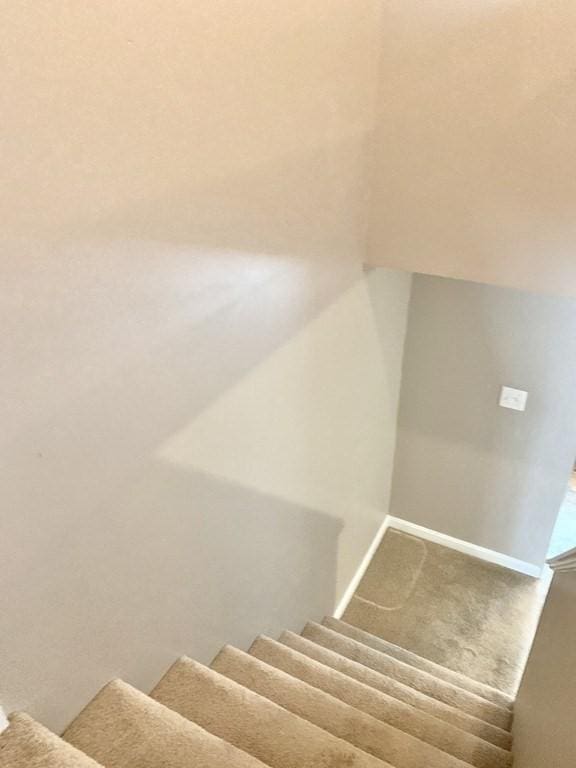 staircase featuring vaulted ceiling and carpet flooring