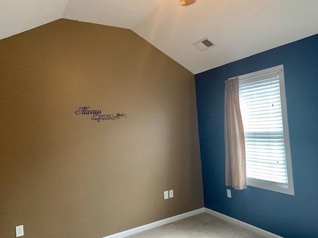 empty room with lofted ceiling, plenty of natural light, baseboards, and carpet