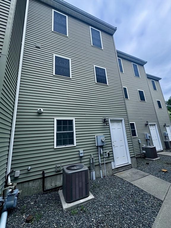 rear view of property with central AC unit