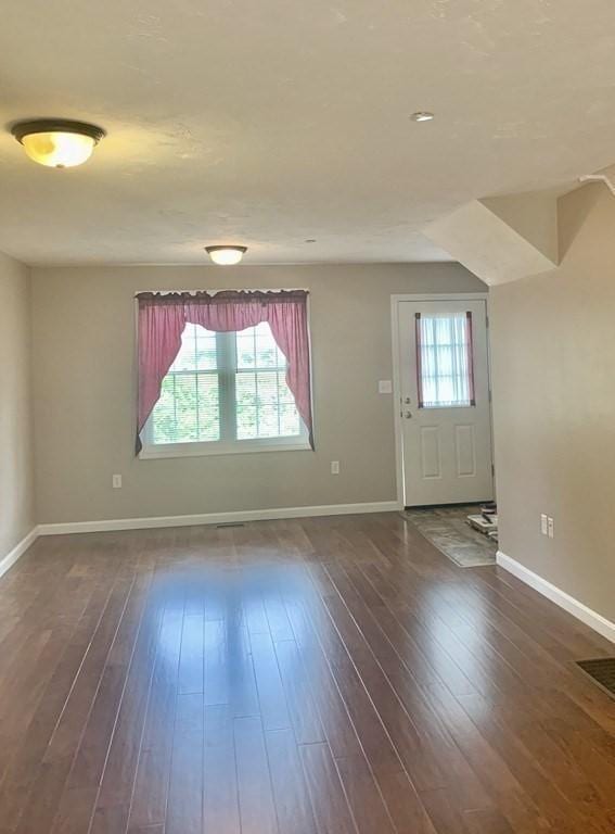 entryway with baseboards and dark wood-type flooring