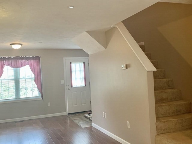 foyer entrance with hardwood / wood-style flooring, stairway, and baseboards