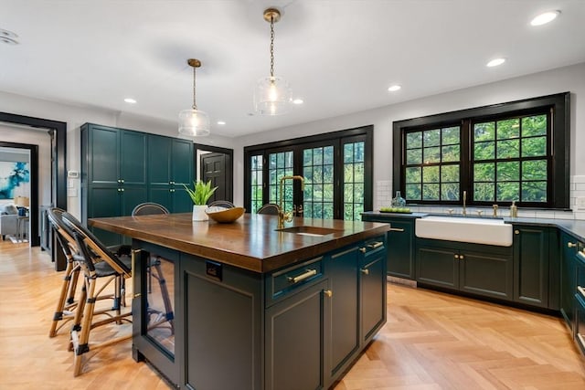 kitchen with tasteful backsplash, wood counters, a sink, and recessed lighting