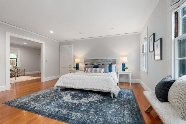 bedroom featuring ornamental molding, baseboards, and wood finished floors