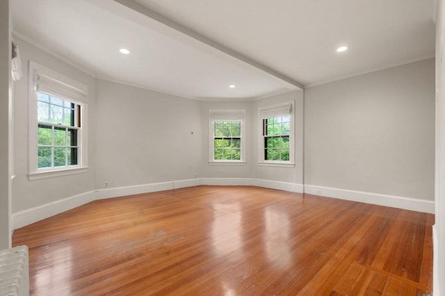 spare room featuring light wood finished floors, baseboards, crown molding, and recessed lighting