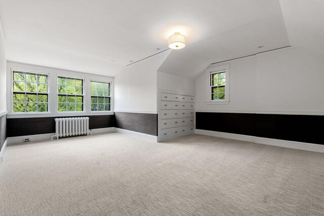 bonus room featuring lofted ceiling, baseboards, carpet flooring, and radiator heating unit