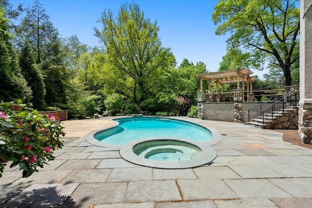 pool with a patio area and an in ground hot tub