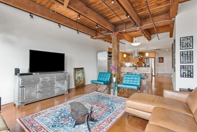9 W Broadway Unit 311, Boston, MA 02127 - living area featuring wooden ceiling with exposed beams, rail lighting, decorative columns, wood finished floors, and baseboards