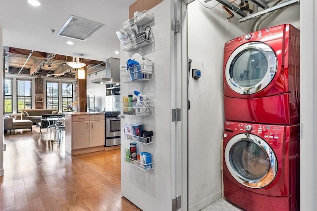 9 W Broadway Unit 311, Boston, MA 02127 - laundry area with stacked washer / dryer, light wood-type flooring, and recessed lighting