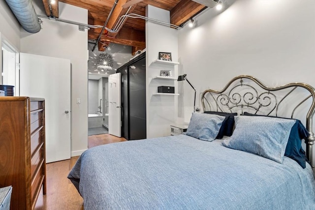 9 W Broadway Unit 311, Boston, MA 02127 - bedroom with wood finished floors, ensuite bathroom, and rail lighting