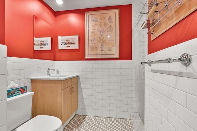 9 W Broadway Unit 311, Boston, MA 02127 - bathroom featuring tile walls, toilet, vanity, wainscoting, and tile patterned flooring