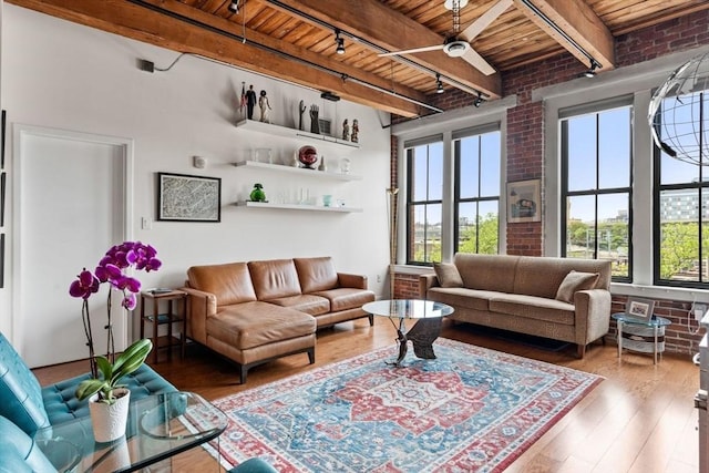 9 W Broadway Unit 311, Boston, MA 02127 - living area with wood ceiling with exposed beams, plenty of natural light, wood-type flooring, track lighting, and brick wall