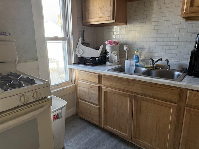 kitchen with backsplash, white gas range, and sink