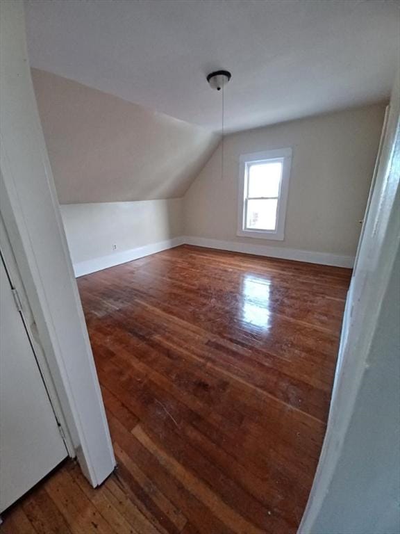 additional living space with dark hardwood / wood-style flooring and lofted ceiling