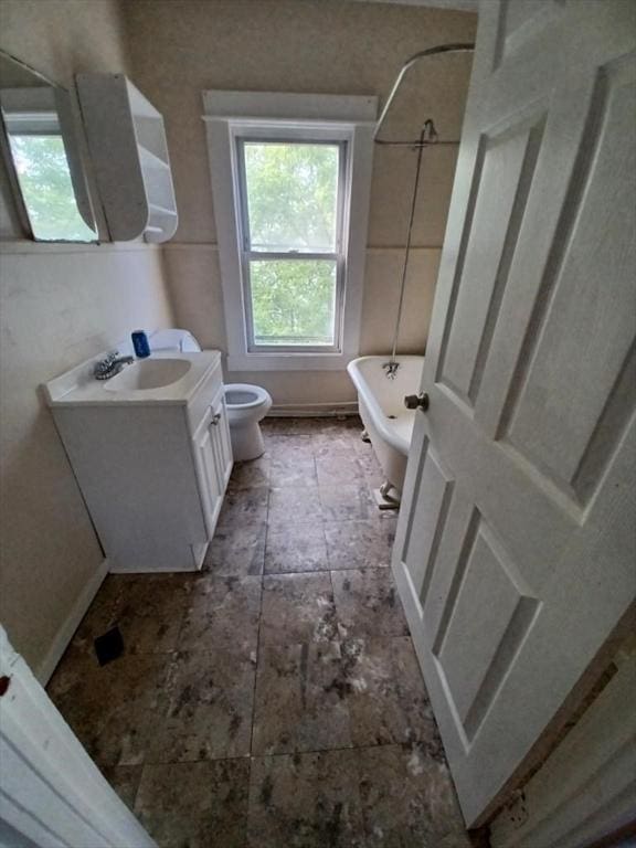 bathroom featuring vanity, toilet, and a tub