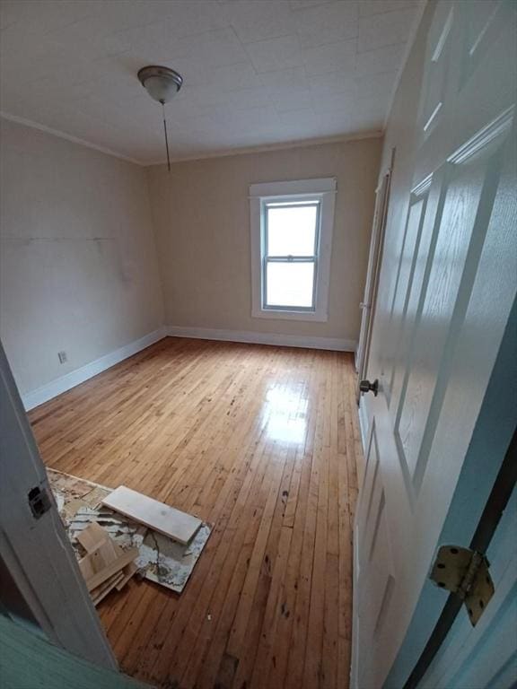 spare room with light hardwood / wood-style flooring and ornamental molding