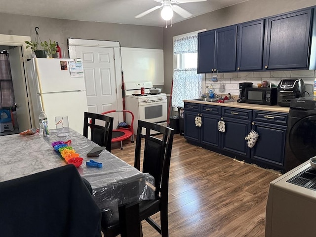 kitchen featuring blue cabinetry, white appliances, washer / clothes dryer, and sink