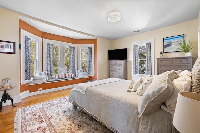 bedroom with wood finished floors and baseboards
