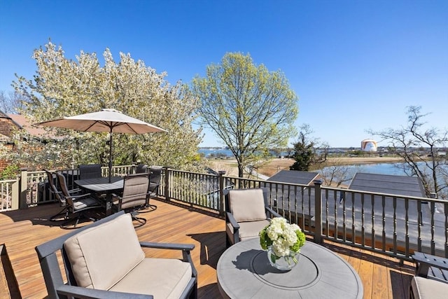 deck featuring outdoor dining space and a water view