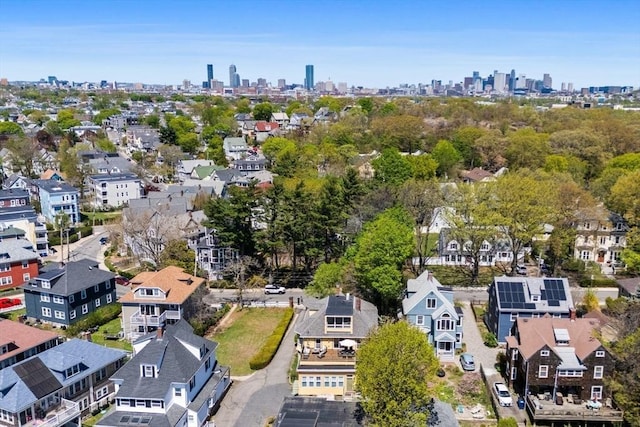 aerial view of property and surrounding area featuring a view of skyline and nearby suburban area